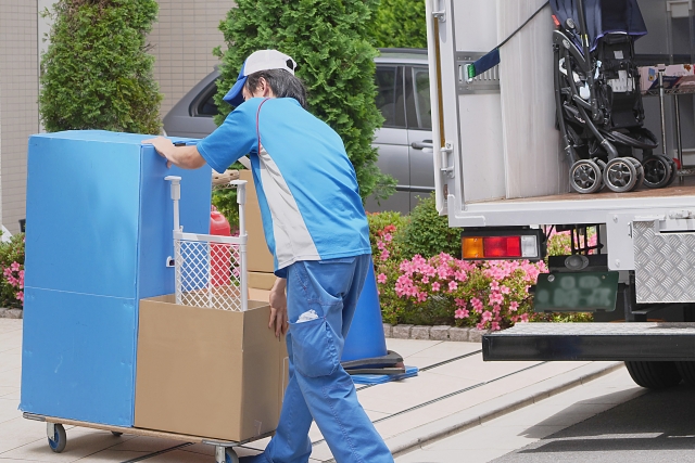 青い作業服で引越作業をする引越し業者