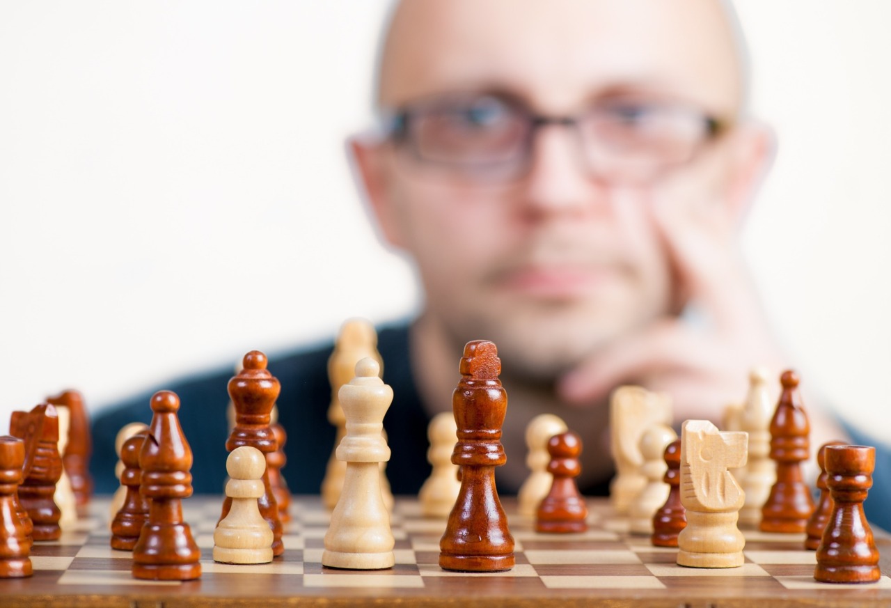 チェスゲームを眺める一人の男。経営目標のクリアーを目指す、上司や幹部のチェスゲーム