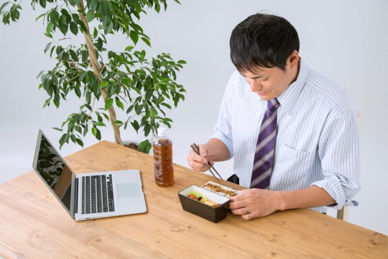 デスクで弁当を食べるサラリーマン